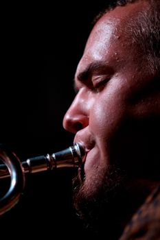A musician deeply focused while playing the trumpet during a live jazz performance.