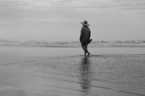 A Person Wearing a Hat Walking on the Sea 
