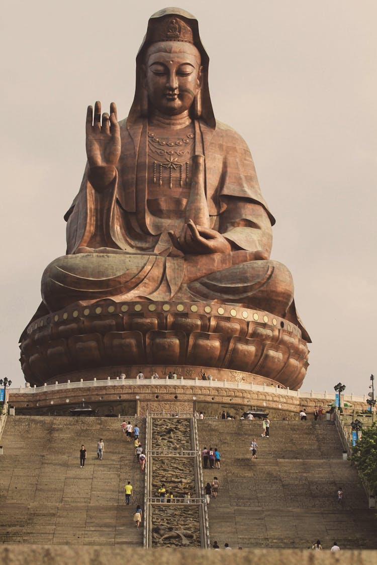 People Walking Near Guanyin Statue