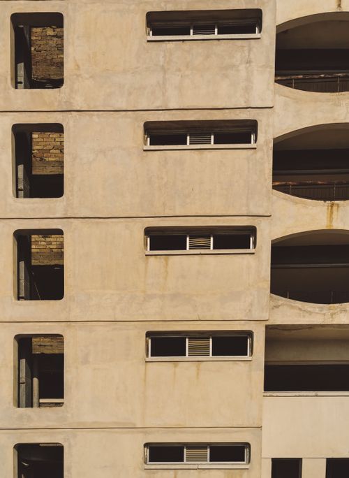 Free Vertical shot of a modern concrete building facade with visible windows and architectural design in Gazimağusa. Stock Photo
