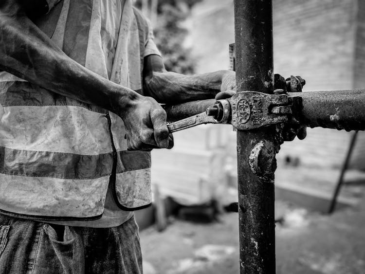 Man Working On A Construction With A Wrench