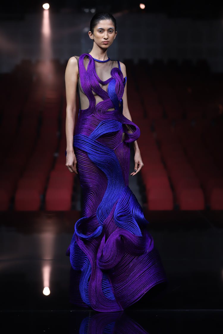 Fashion Model In Elegant Purple Gown Posing On Stage