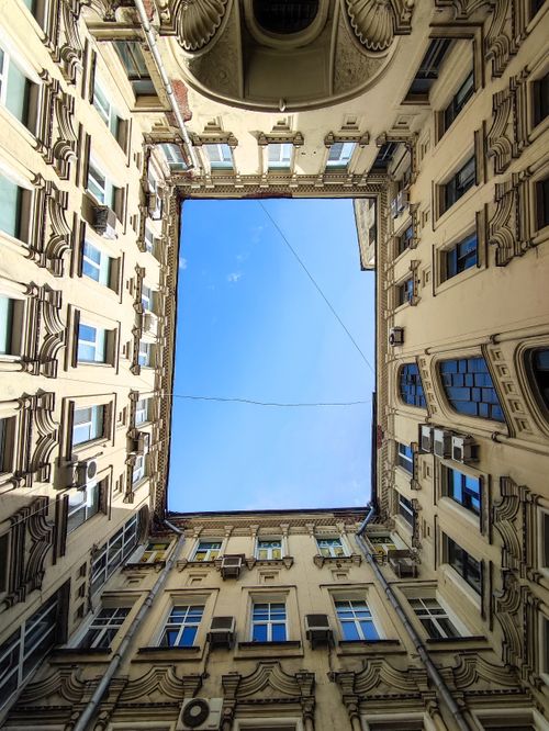 Free Looking up through classic architectural courtyard framing a blue sky Stock Photo