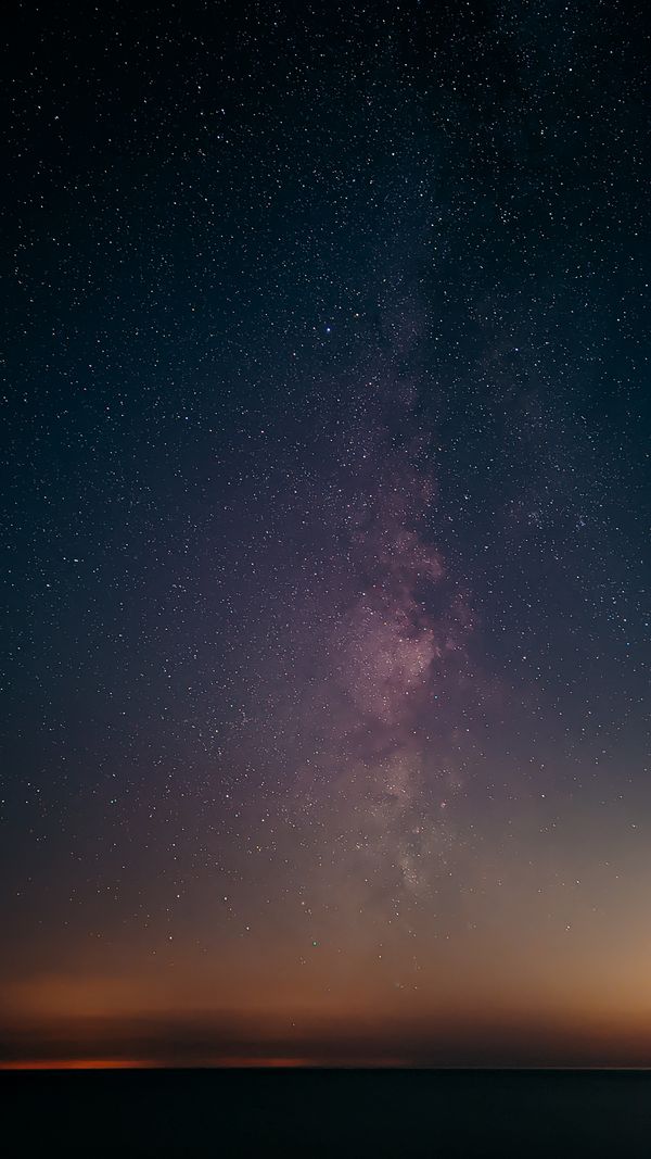 Impressionante foto vertical da Via Láctea com estrelas em um céu noturno sereno.