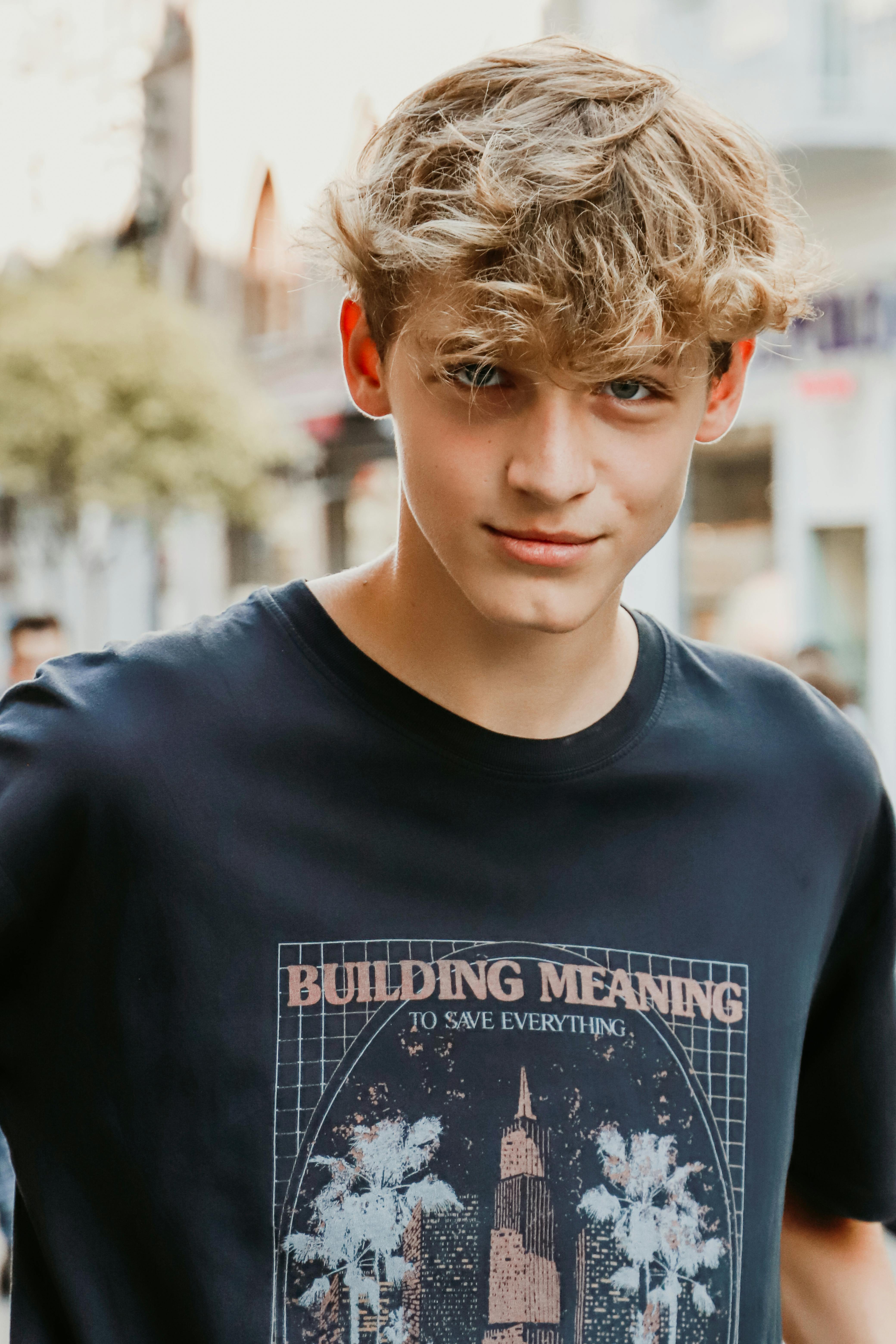 Young man with wavy hair wearing a graphic t-shirt in Istanbul street.