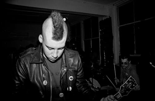 A Grayscale of a Guitarist in a Leather Jacket