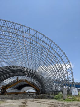 Large steel frame structure under a clear blue sky in Bangladesh, showcasing modern engineering.