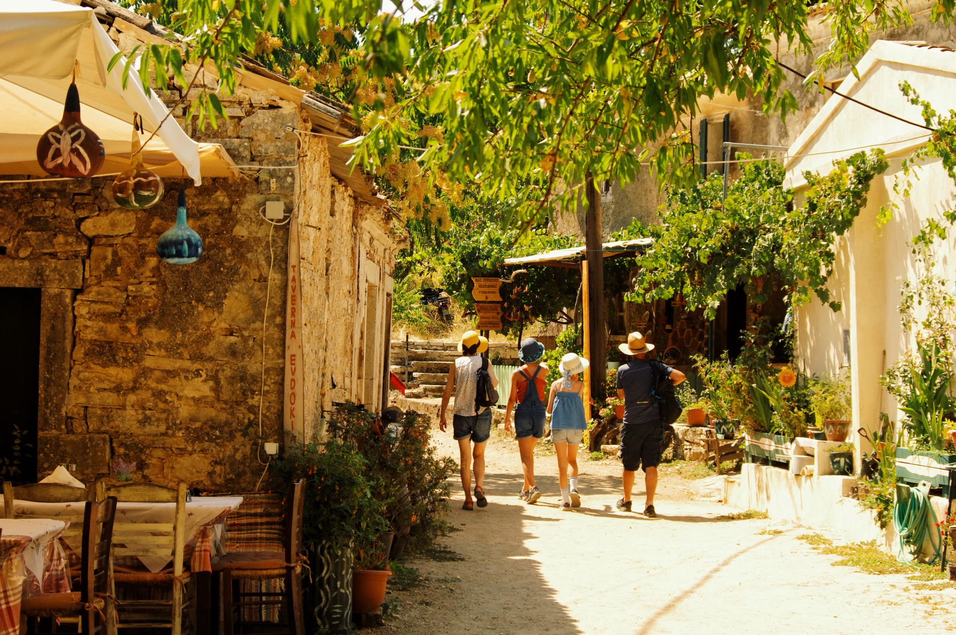 Tourists exploring the rustic charm of Peritheia village in Greece.