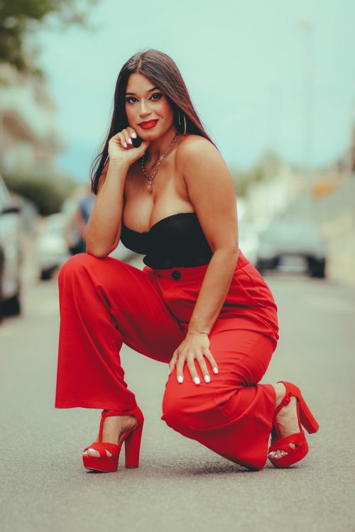 Free Confident woman in vibrant red pants posing on the street, embodying modern fashion and style. Stock Photo