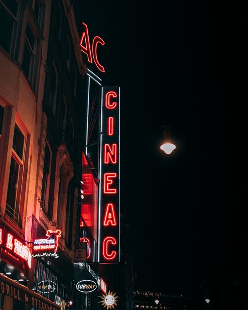 Free A vibrant neon lit street scene in Amsterdam at night, showcasing urban architecture. Stock Photo