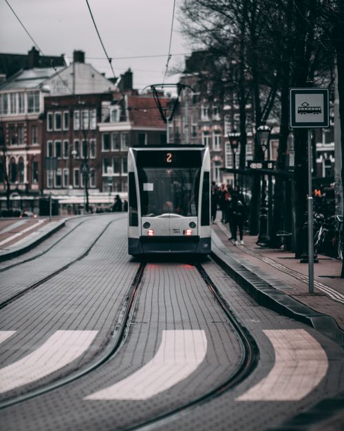 Free A city tram travels through the streets of Amsterdam, capturing urban life and public transportation. Stock Photo