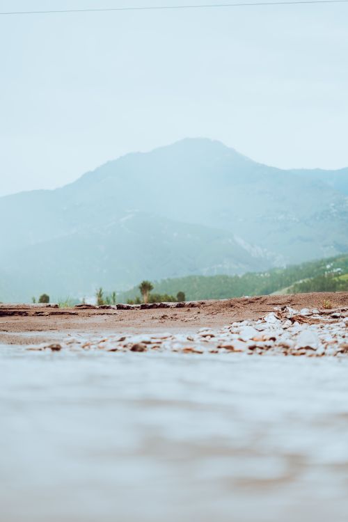Free Serene mountain landscape with a foreground stream and distant peaks. Stock Photo