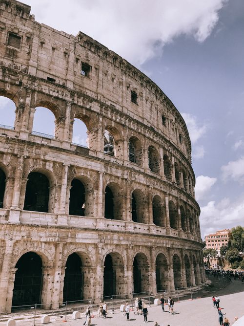 Free Iconic view of the ancient Colosseum in Rome, Italy with a sunny sky and tourists. Stock Photo