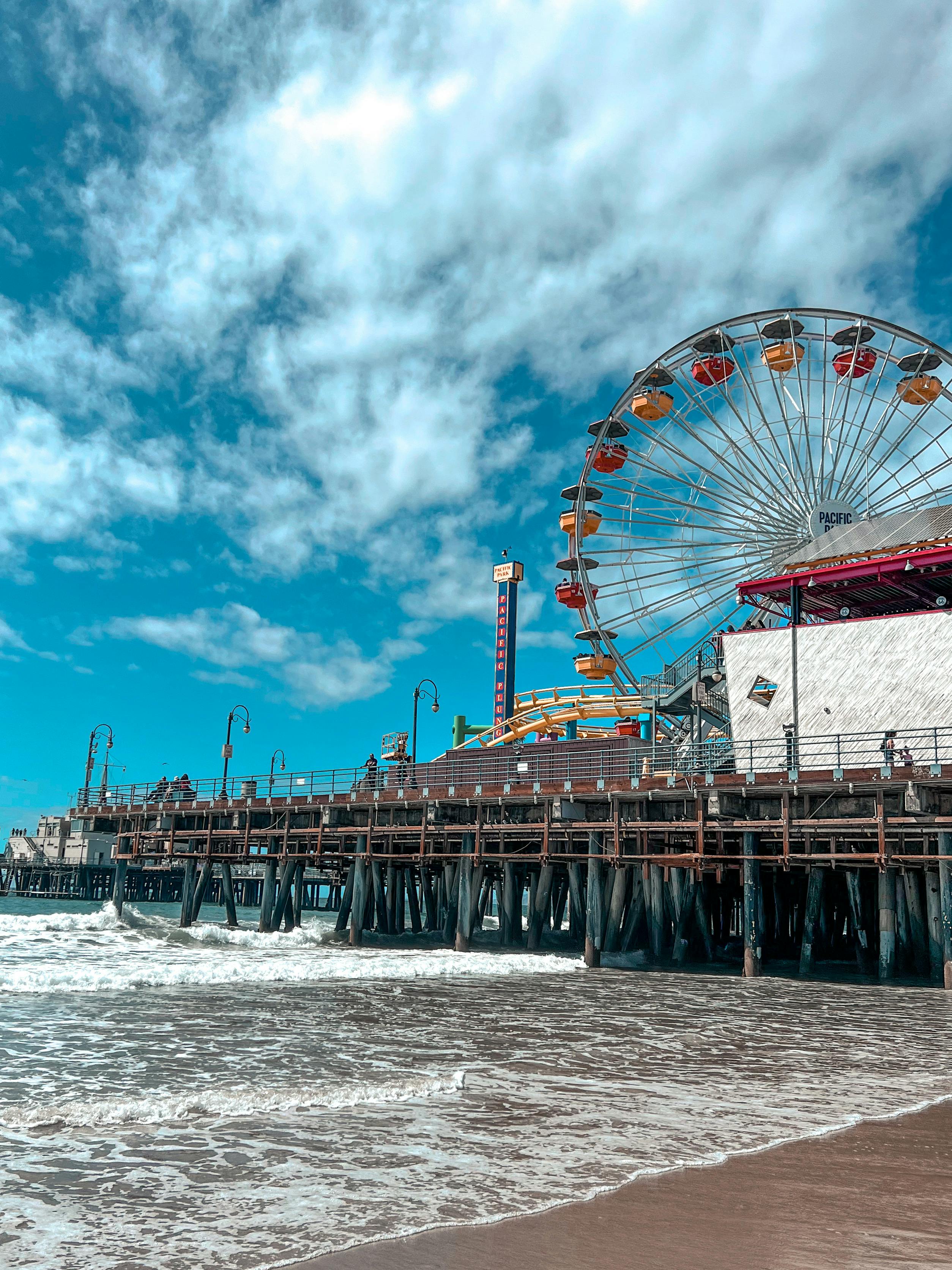 ferris wheel near body of water under blue sky