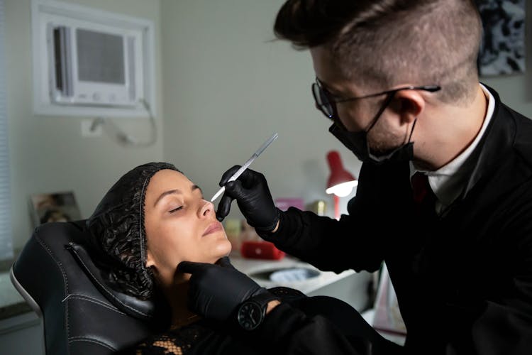 Man Doing Permanent Makeup On Patient