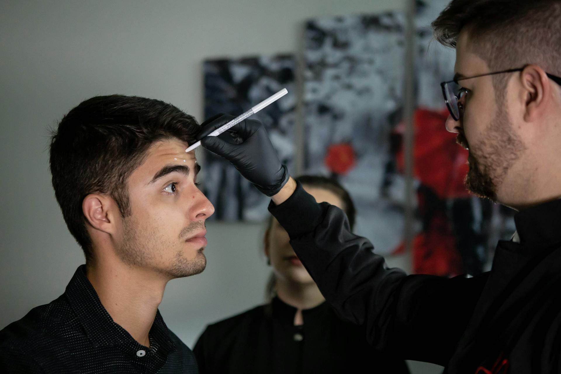 A Man Putting Markings on His Client's Forehead