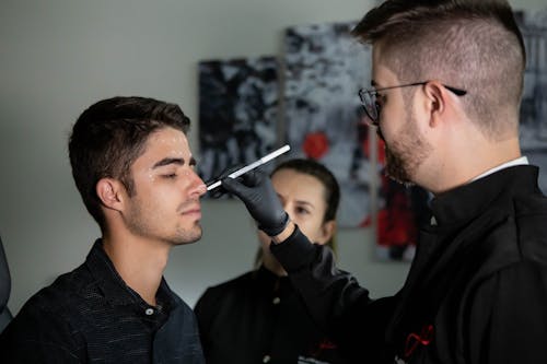 A Man Marking His Client's Face