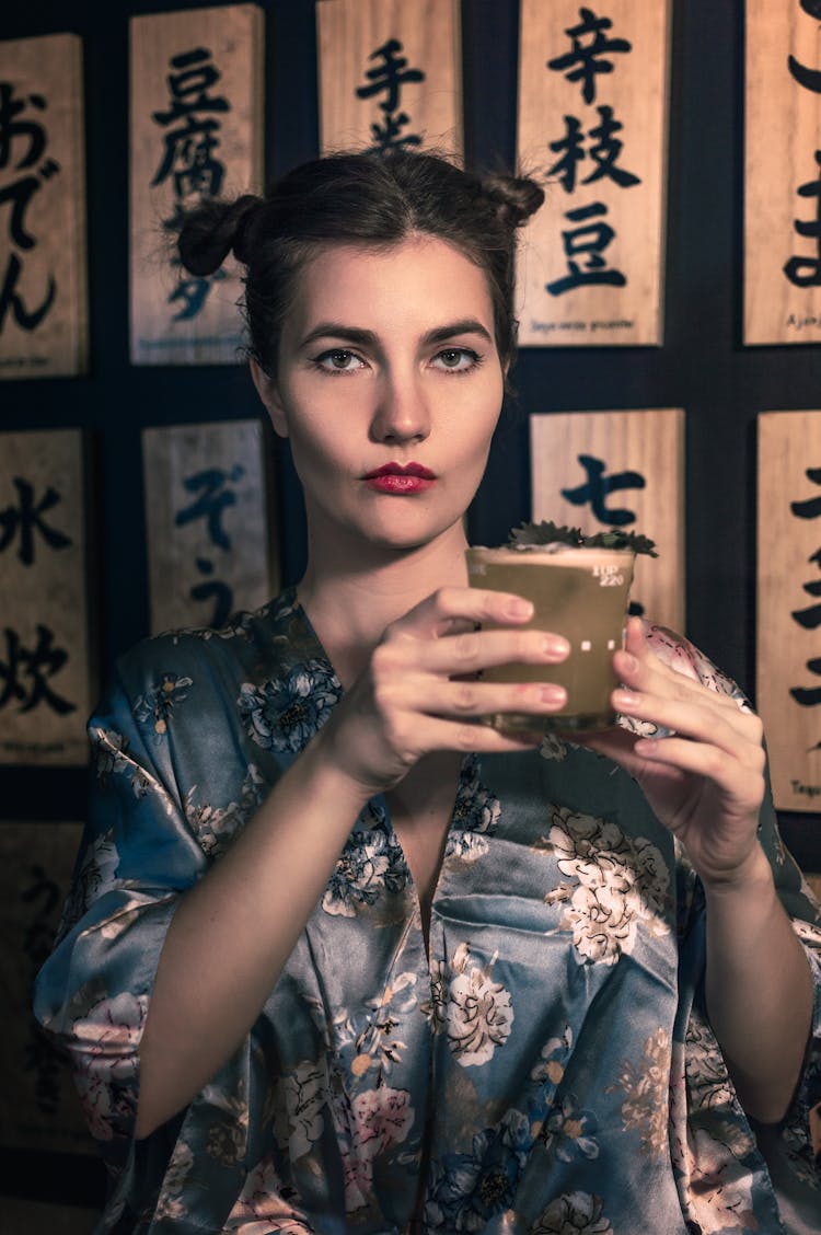 Young Woman In Japanese Kimono Holding Glass Of Drink