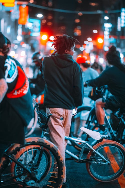 Free Group of Teenagers on Bikes in Downtown at Night Stock Photo