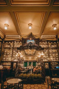 Classic restaurant setting with people, ornate decor, and warm lighting.