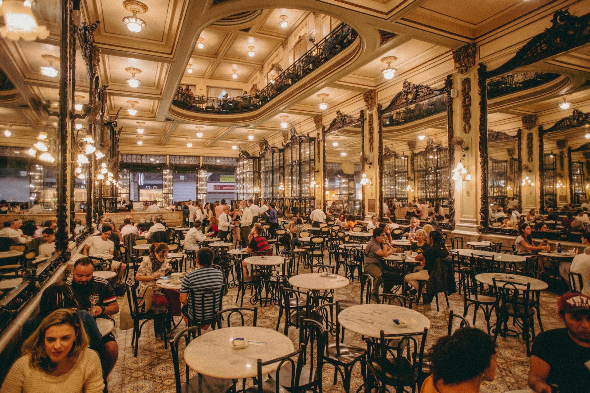 Elegant historic restaurant interior with patrons dining and ornate decor, providing a classic ambiance.