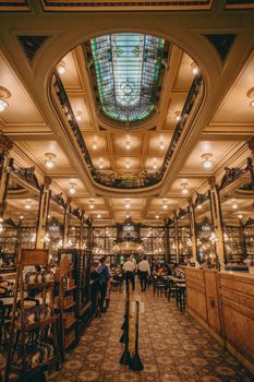 Capture of an opulent vintage restaurant interior with a stunning skylight and classic decor.