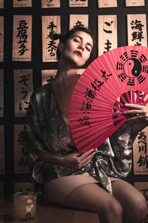 A Woman in Floral Dress Holding a Hand Fan