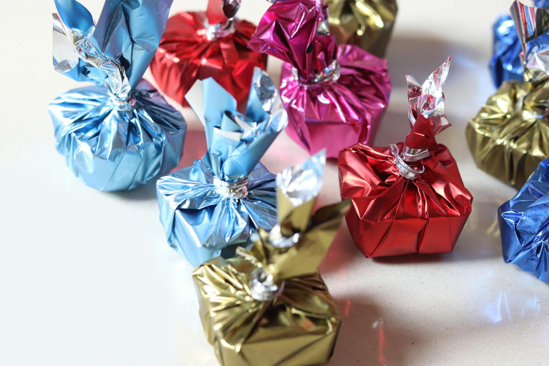 Cluster of colorful wrapped gifts in shiny foil, perfect for festive occasions.
