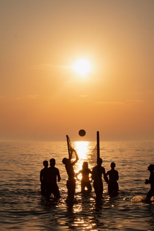 Free Silhouette of friends playing beach volleyball at sunset in Durrës, Albania. Stock Photo