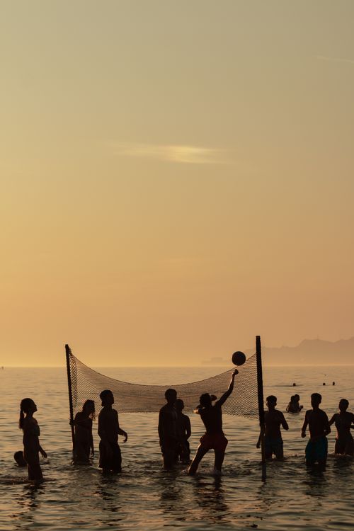 Free Silhouettes of people playing beach volleyball at sunset in Durrës, Albania. A serene and fun outdoor activity. Stock Photo