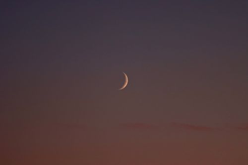 Free A beautiful crescent moon glows softly in a dusky sky over Jönköping, Sweden. Stock Photo