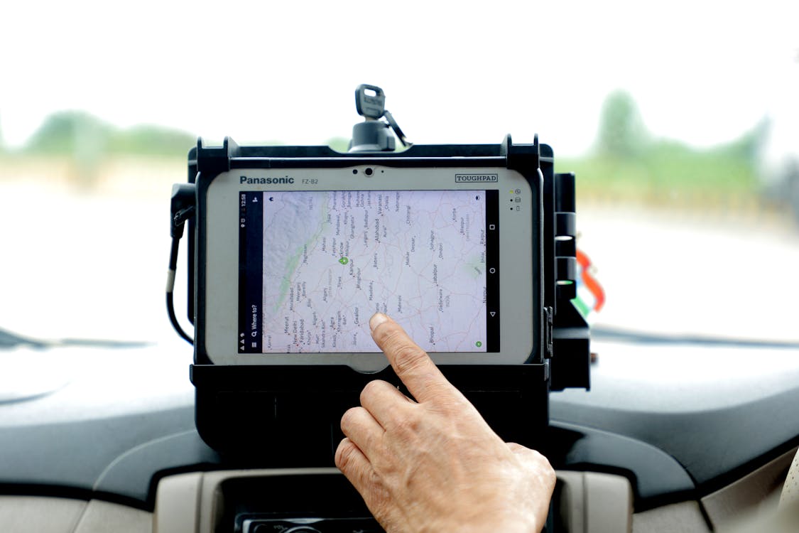 Free Hand Touching GPS Tracker in Car Stock Photo