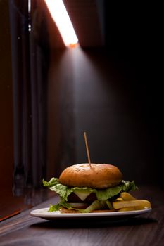 A delicious, gourmet cheeseburger with fresh lettuce under a dramatic spotlight.