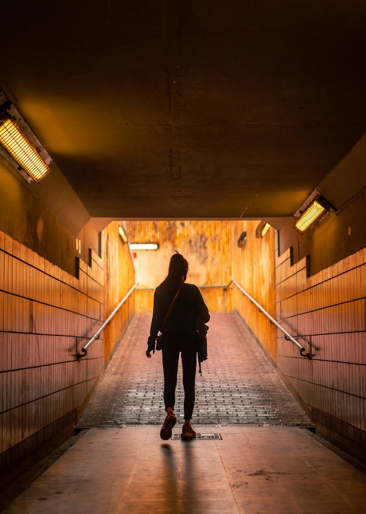 A Woman Walking Under The Tunnel