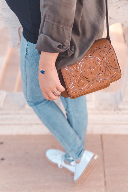 Free Stylish woman showcasing denim jeans and a leather bag in Rabat, Morocco. Stock Photo