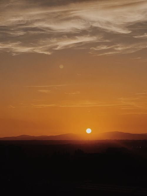 Free Captivating landscape with dramatic golden hour sunset over mountains and clouds. Stock Photo