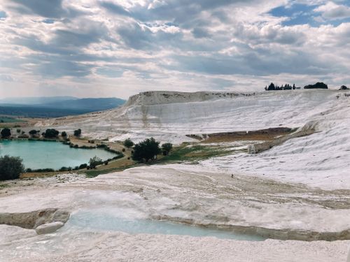 Free Capture of Pamukkale's stunning white travertine terraces in Denizli, Turkey, under a cloudy sky. Stock Photo