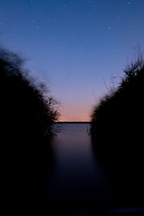 Free Starry night sky over a calm river in Halle, Germany, with vibrant twilight colors. Stock Photo