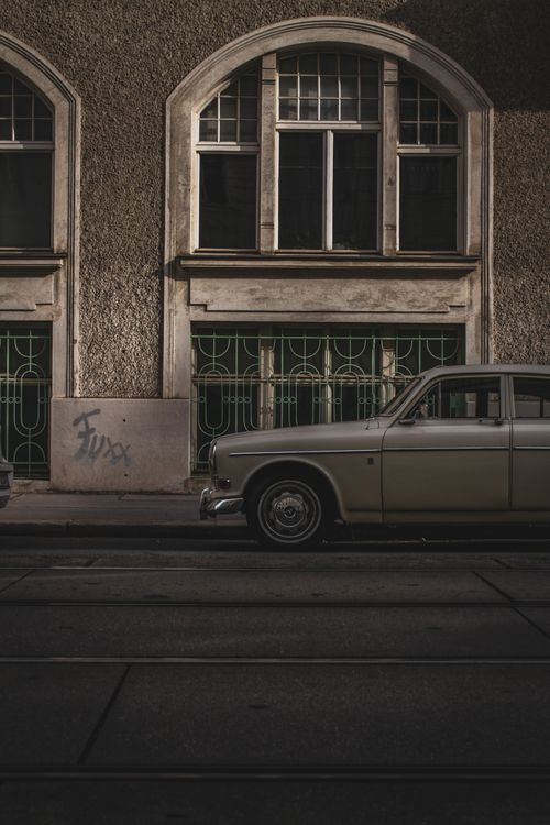 Free A vintage car parked on a historic street in Vienna, Austria, with classic architecture in the background. Stock Photo