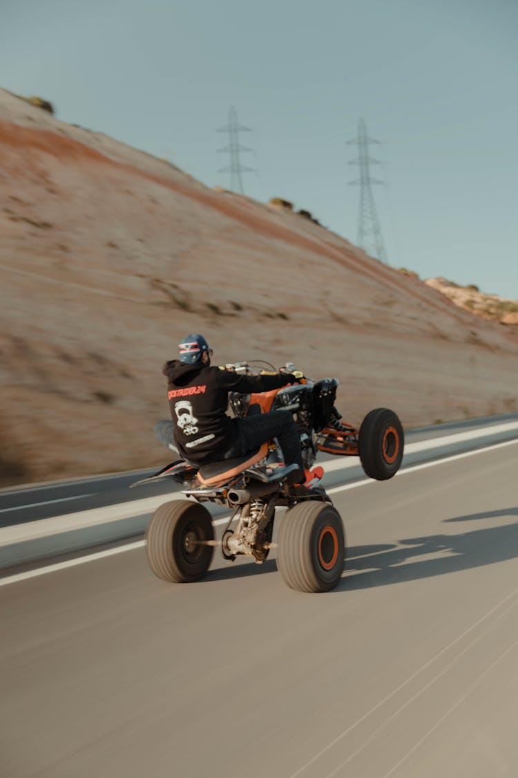 A Man Black Hoodie Driving ATV On The Road