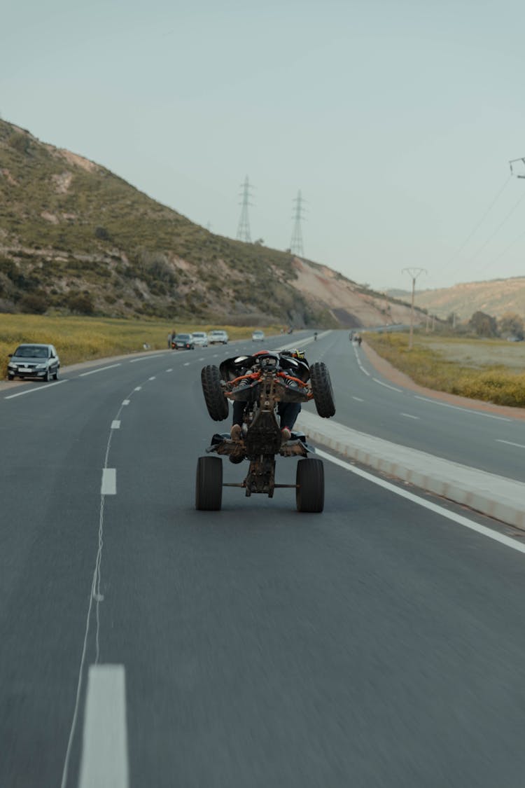 A Man Wheelieing On The Road