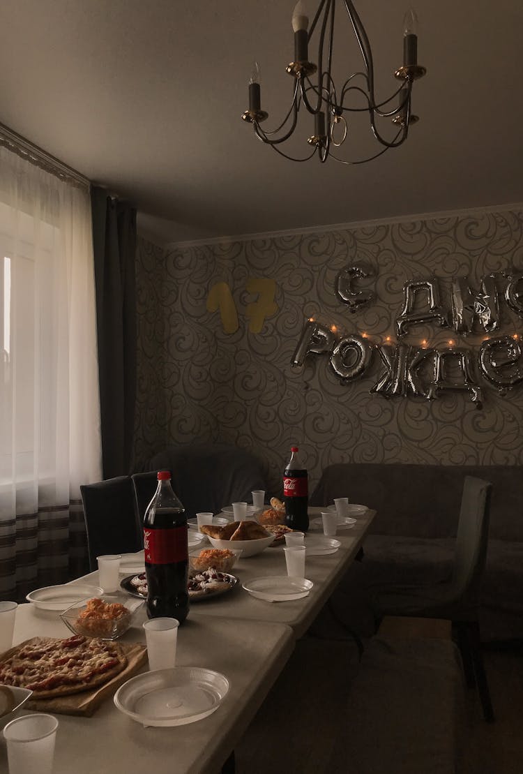 A Table Setting With Food And Bottles Of Soda During A Birthday Celebration