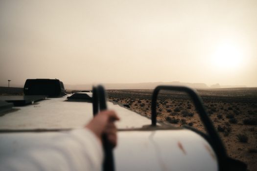 A scenic view from a rooftop overlooking a desert landscape at sunset, creating a moody ambiance.