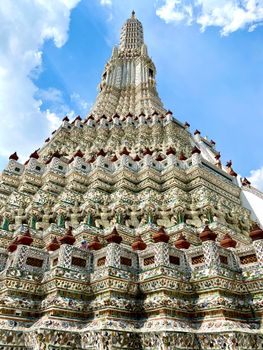 Exquisite low angle view of the ornate Wat Arun temple under a clear blue sky in Bangkok.