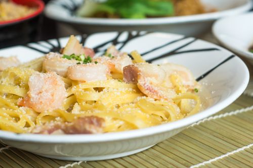 Free Close-up of fettuccine pasta topped with shrimp, bacon, and parmesan cheese. Stock Photo