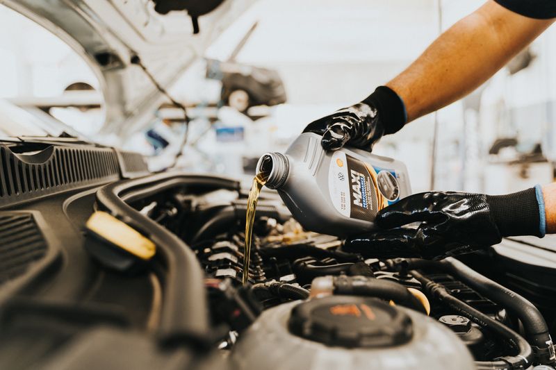 Mechanic performing an oil change on a car