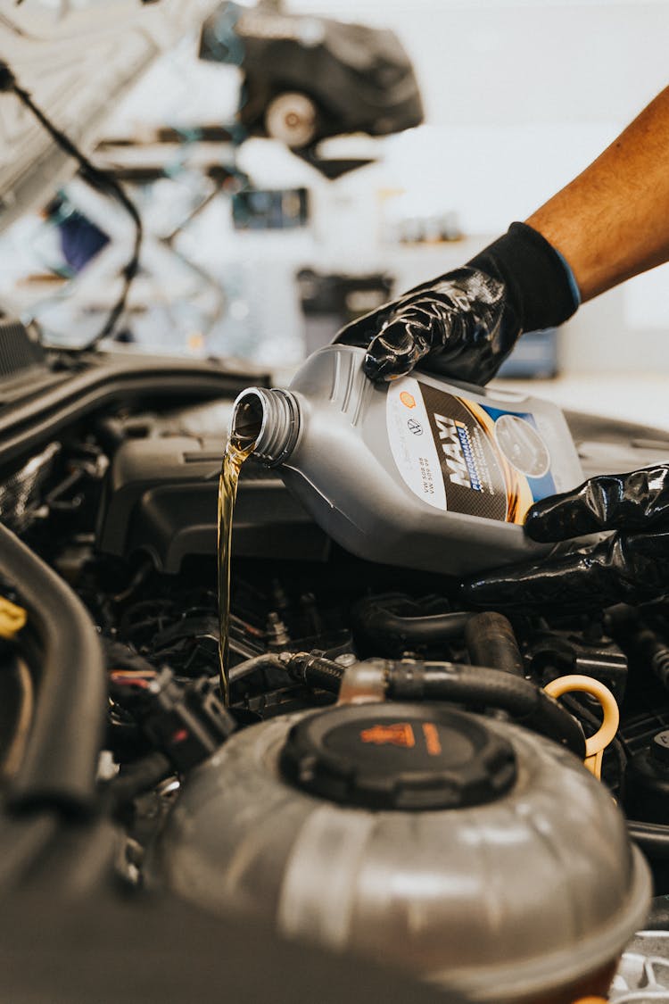 Hands Pouring Oil To Engine