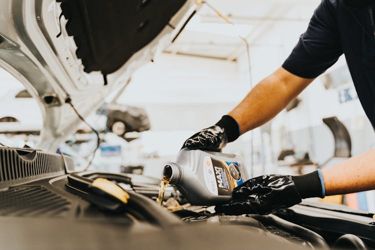 Hands Pouring Oil To Engine