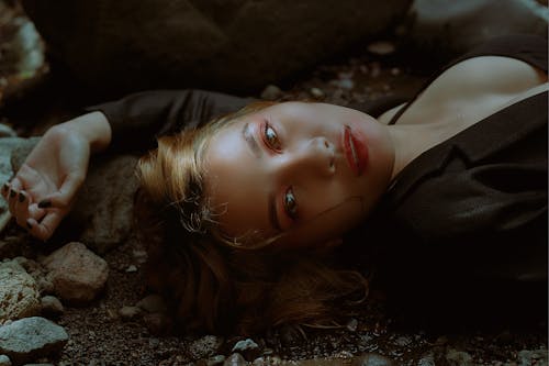Free A Woman in Black Blazer Lying on the Ground Stock Photo