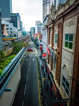 Aerial street view of Kuala Lumpur, showcasing modern and historic buildings, lush greenery, and vibrant city life.